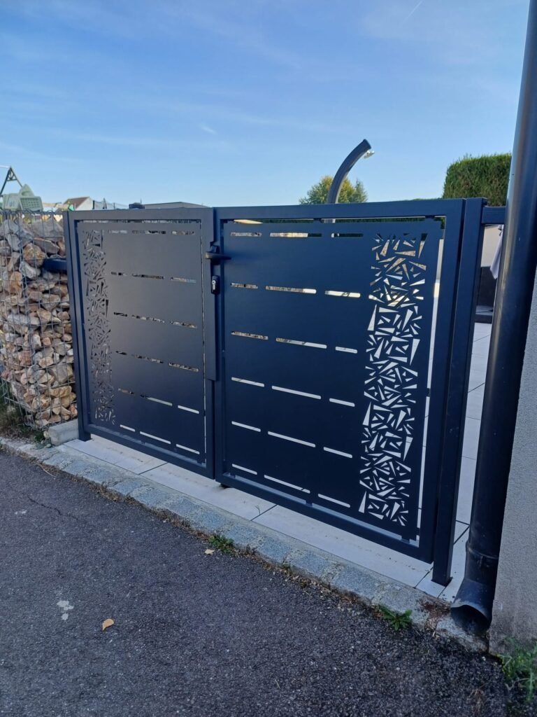 Portail à deux battants en métal thermolaqué avec découpe laser décorative, réalisé sur mesure par Serrurier Express H24 à Dannemarie (Haut-Rhin). Fabrication de portails métal, découpe laser design et thermolaquage sur mesure à Dannemarie, Altkirch, Mulhouse, Belfort et le Territoire de Belfort. Tél : 0643188479 - 7 rue de Zaporojie 90000 Belfort / 20 rue d'Agen 68000 Colmar