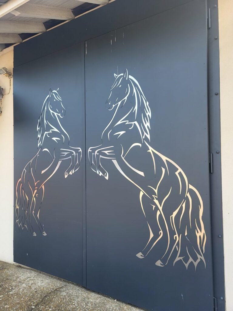 Porte d'écurie / portail battant en métal thermolaqué sur mesure, avec découpe laser motif cheval cabré, réalisé par Serrurier Express H24 à Burnhaupt-le-Haut (Haut-Rhin). Fabrication de portes et portails d'écurie, découpe laser décorative et métallerie sur mesure à Burnhaupt-le-Haut, Masevaux, Thann, Mulhouse et le Territoire de Belfort. Tél : 0643188479 - 7 rue de Zaporojie 90000 Belfort / 20 rue d'Agen 68000 Colmar